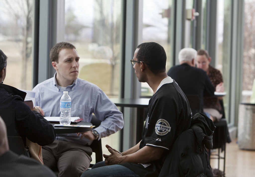 Two people in conversation at a community financial literacy event